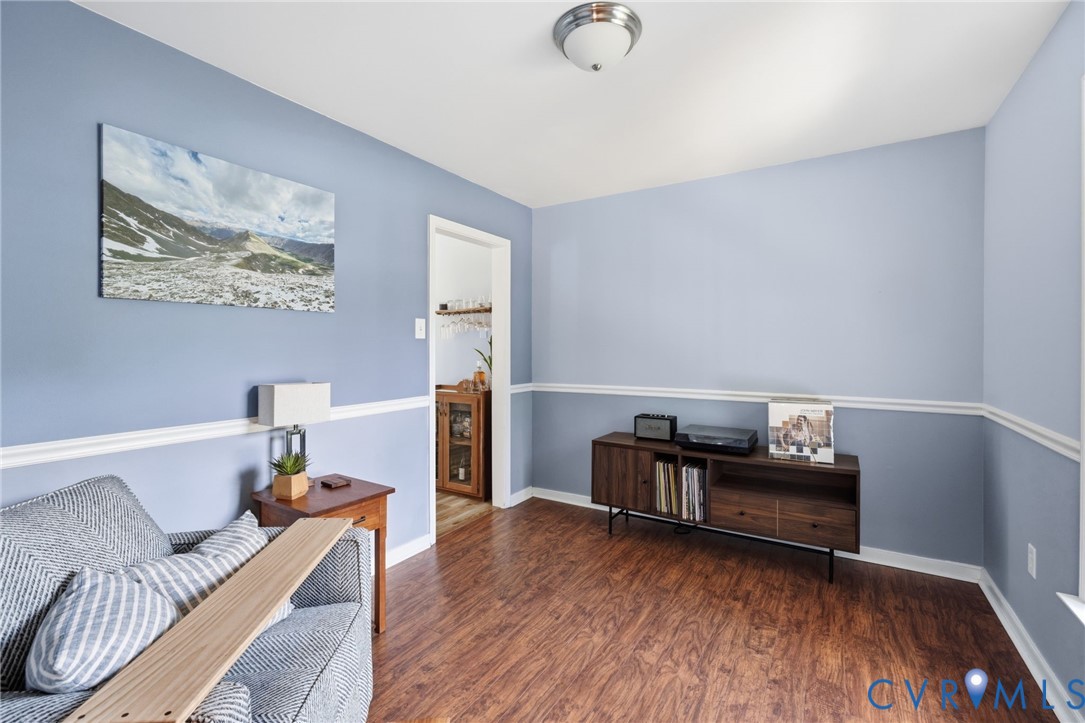 Wood-finish flooring, two-tone painted walls with chair rail, and a semi-flush mount ceiling light