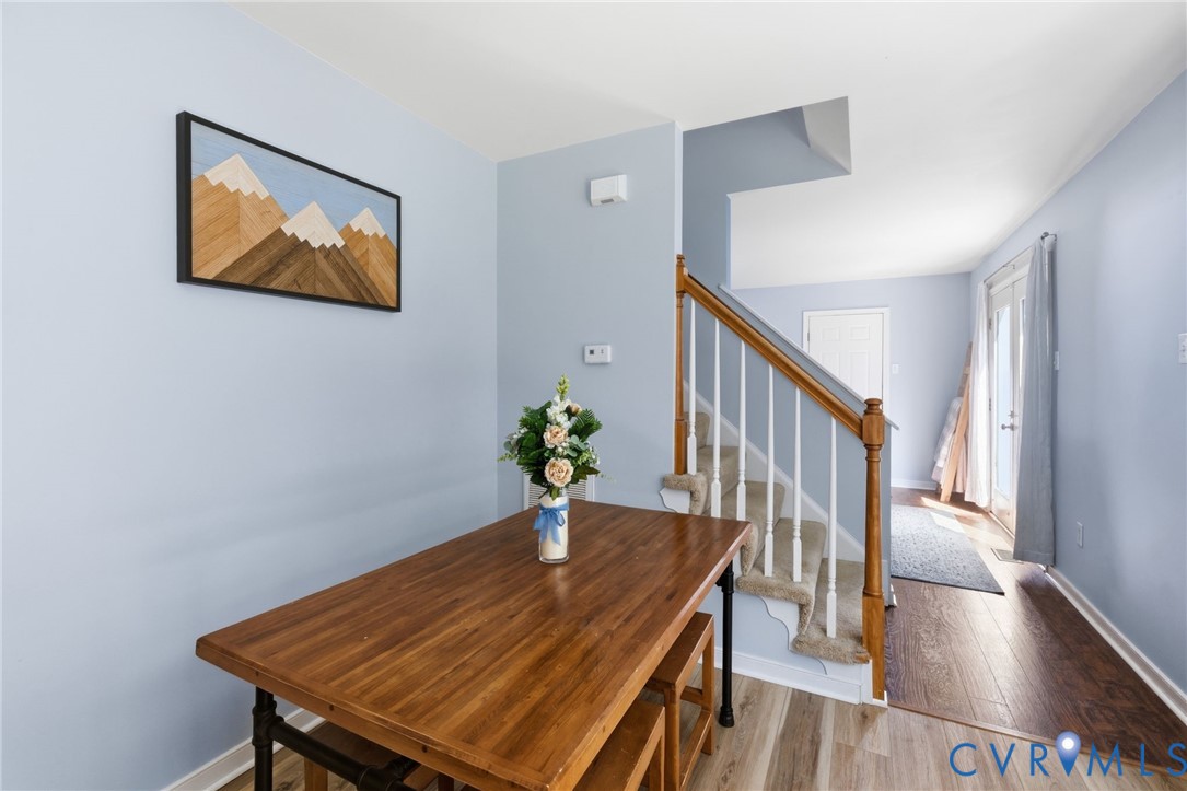 Wood-finish flooring, staircase with wood handrail, light blue wall paint, French doors, recessed entry
