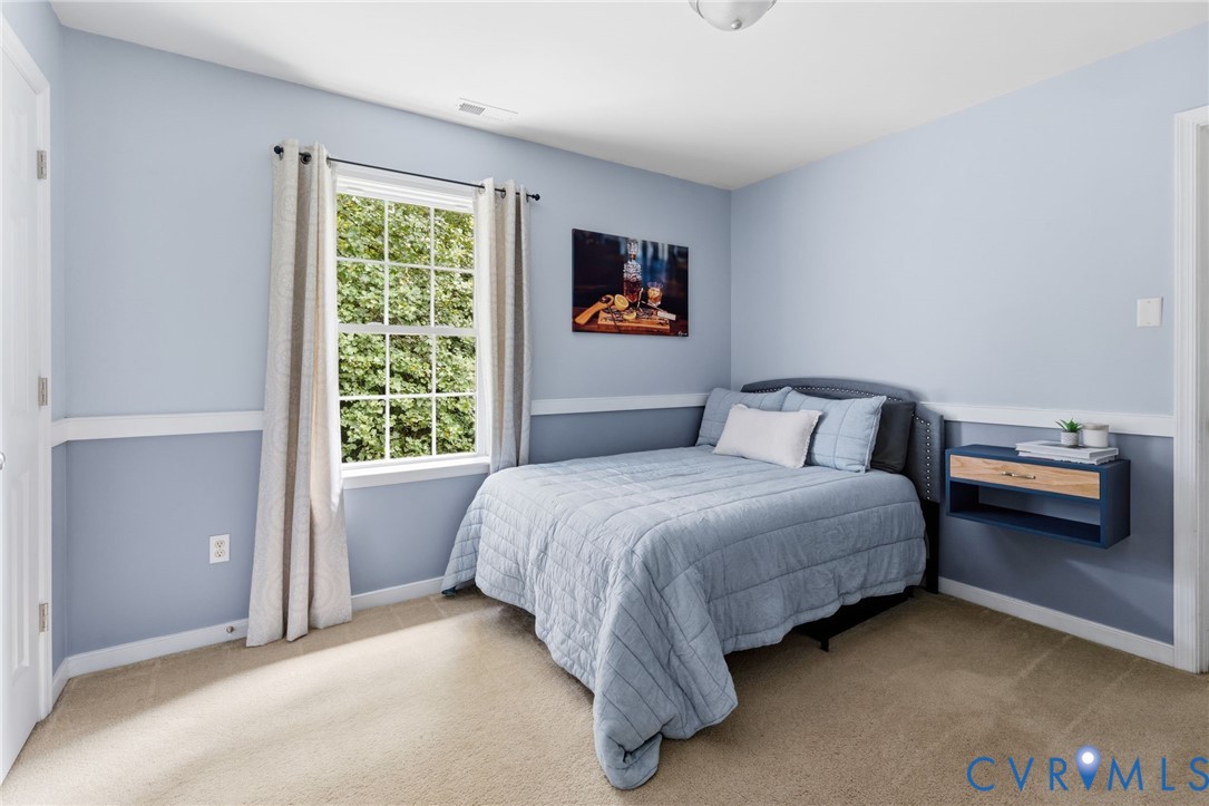 Carpeted room featuring a white-trimmed window, a built-in wall shelf with wood-finish drawer, and a flush-mount ceiling light