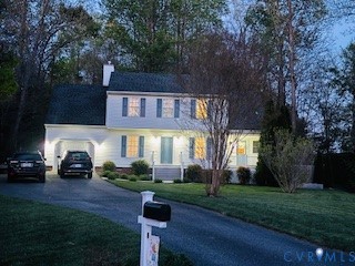 Two-story residence with a covered carport, paved driveway, and mature landscaping
