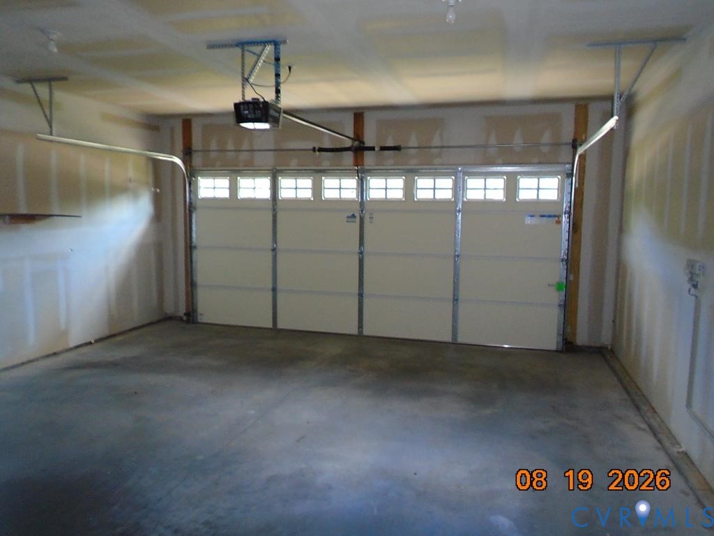 Single-bay garage featuring a concrete floor and an automatic garage door opener