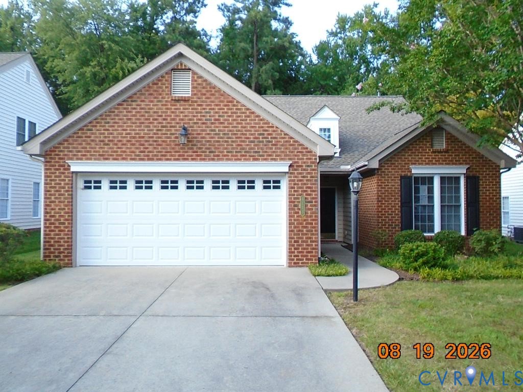 Brick facade with an integrated two-car garage, a concrete driveway, and a paved walkway Brick facade with an integrated two-car garage, a concrete driveway, and a paved walkway