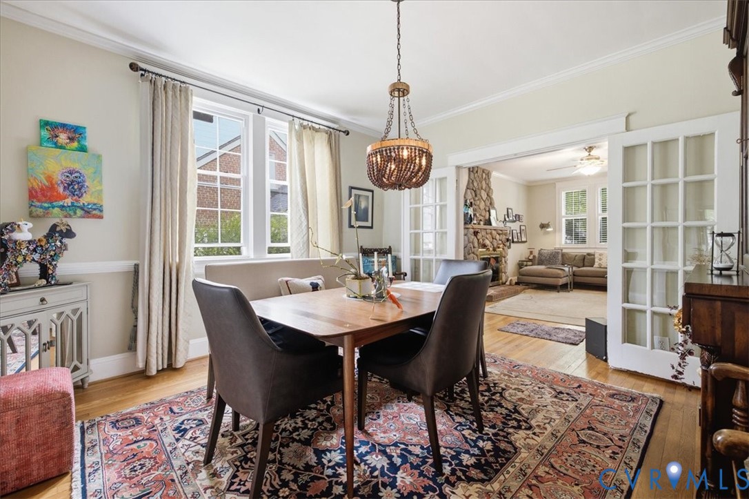 Hardwood flooring throughout, crown molding, and a beaded chandelier