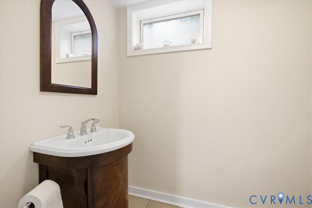 Pedestal vanity with a porcelain sink and chrome faucet in basement