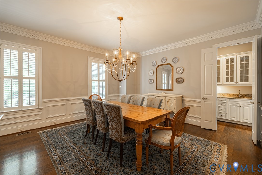Hardwood flooring, crown molding, and wainscoting details
