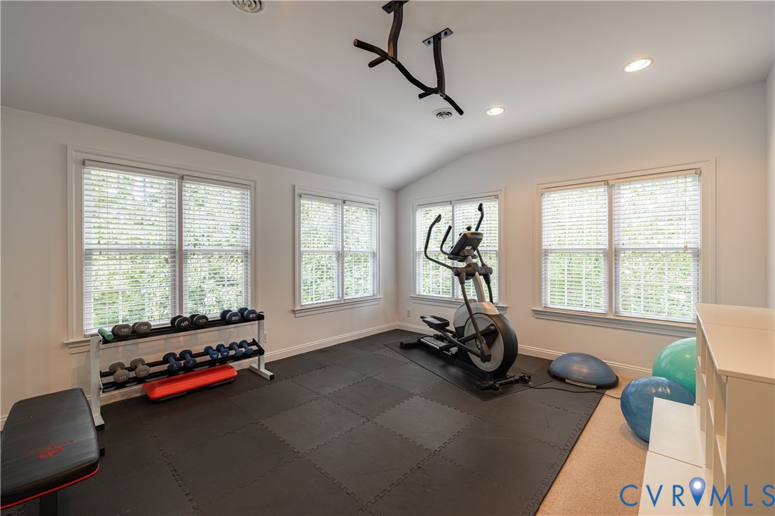 Vaulted ceiling, recessed lighting, wall-mounted pull-up bar, and specialized rubber flooring