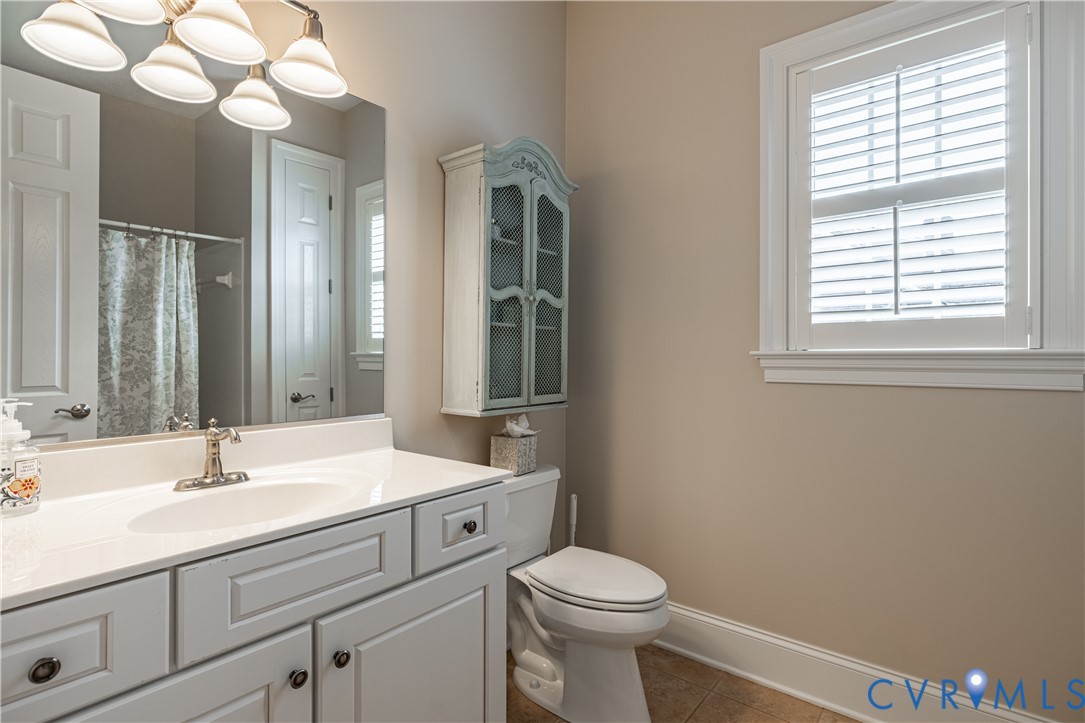 Vanity with integrated sink, large mirror, and window with plantation shutters
