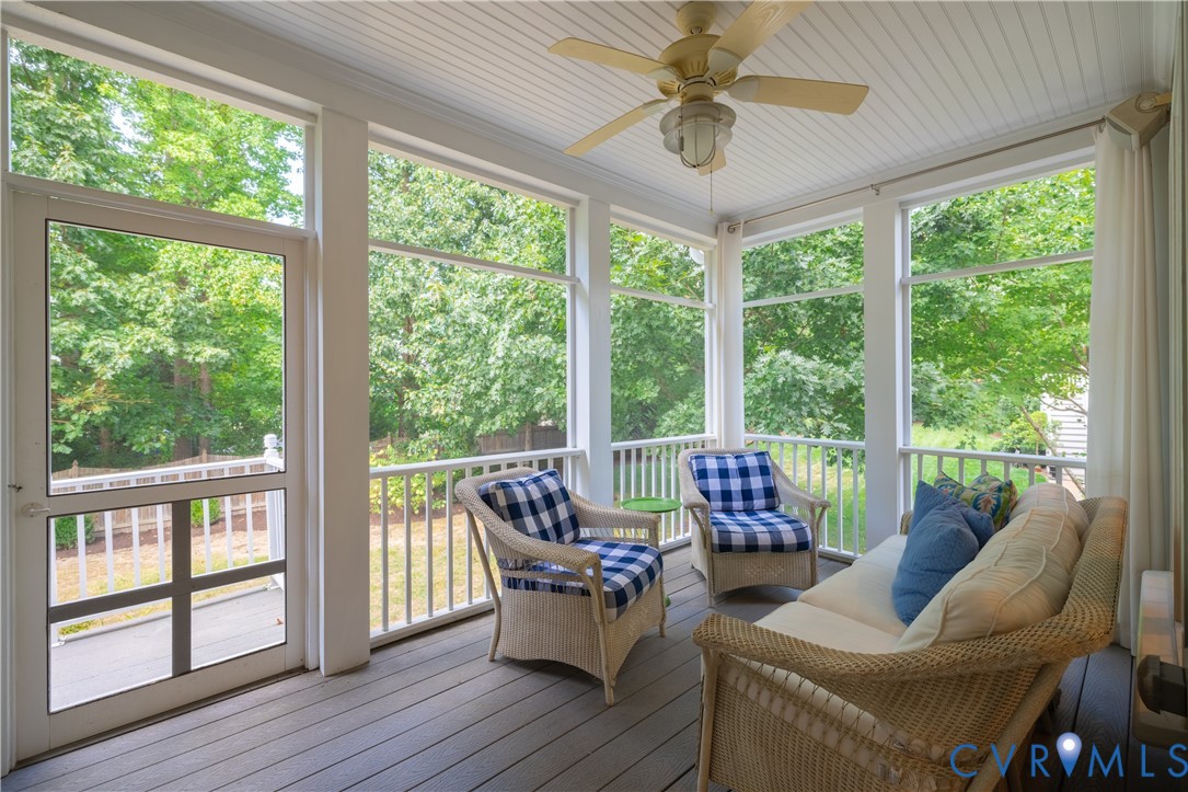 Screened porch featuring a white beadboard ceiling, overhead ceiling fan