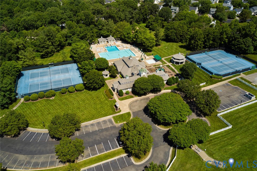 Expansive grounds featuring multiple tennis courts, a large swimming pool, and a dedicated parking area