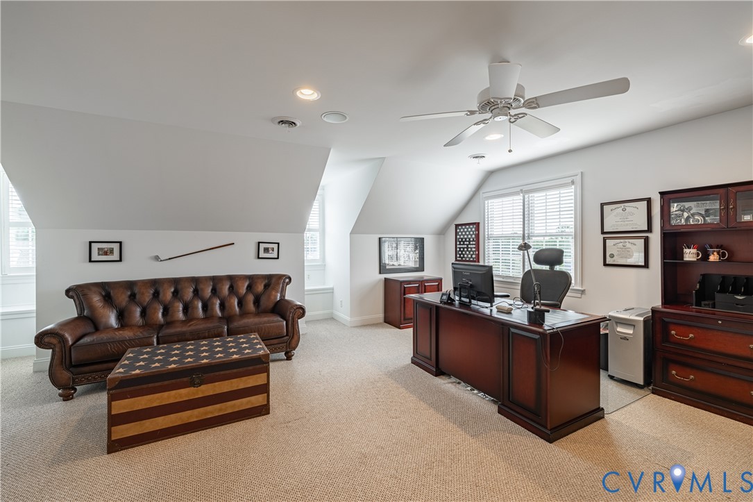 Carpeted room featuring a ceiling fan, recessed lighting, and multiple windows with blinds