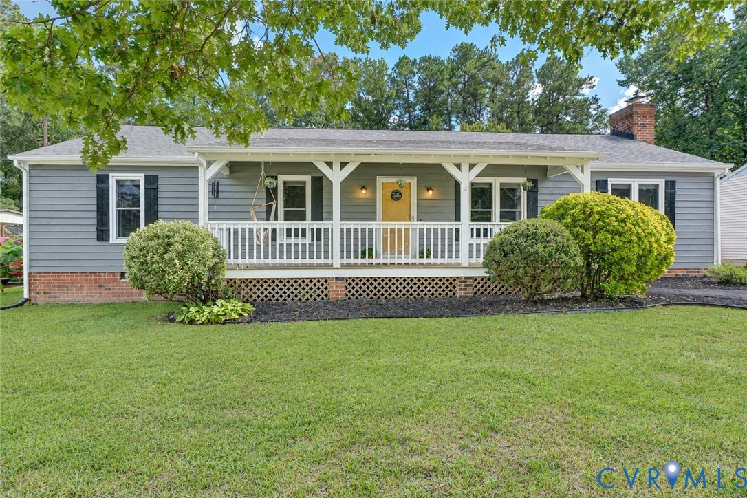 Ranch-style exterior with gray siding, a covered front porch featuring white railings, and a contrasting yellow entry door
