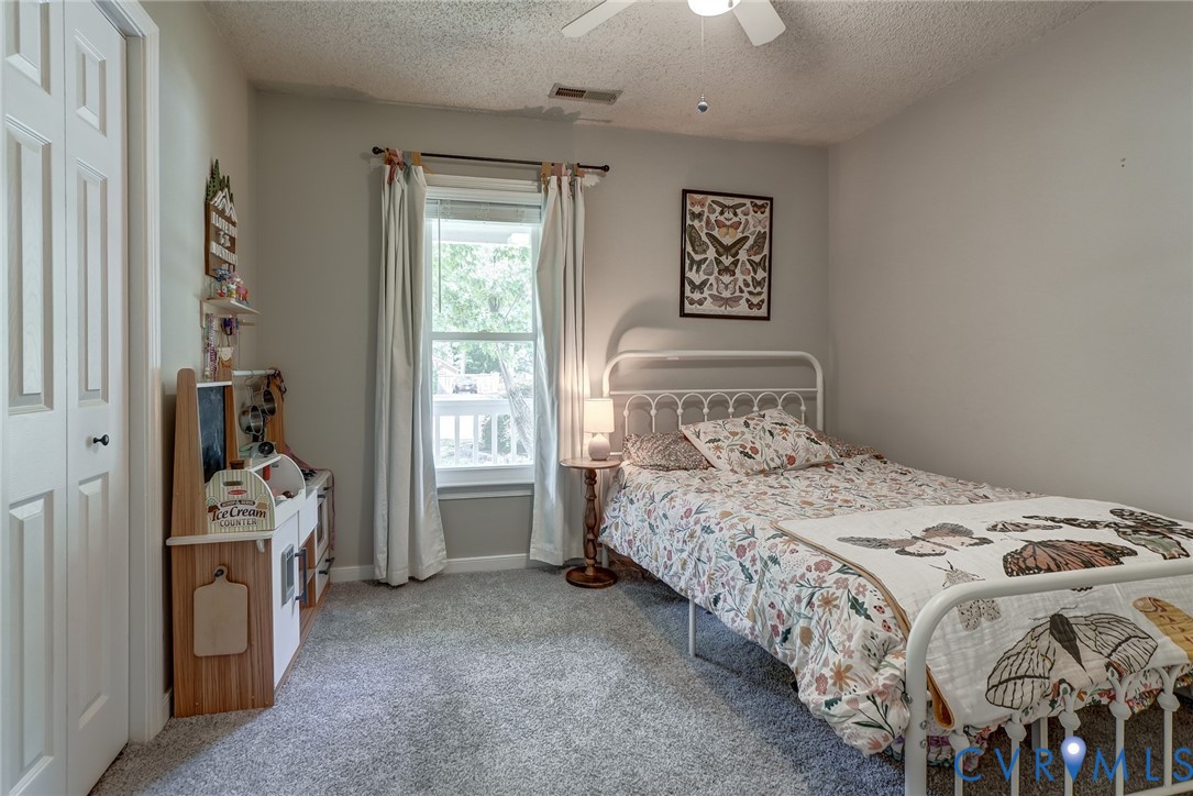 Soft gray wall paint with textured ceiling, white bi-fold closet doors, and white window trim