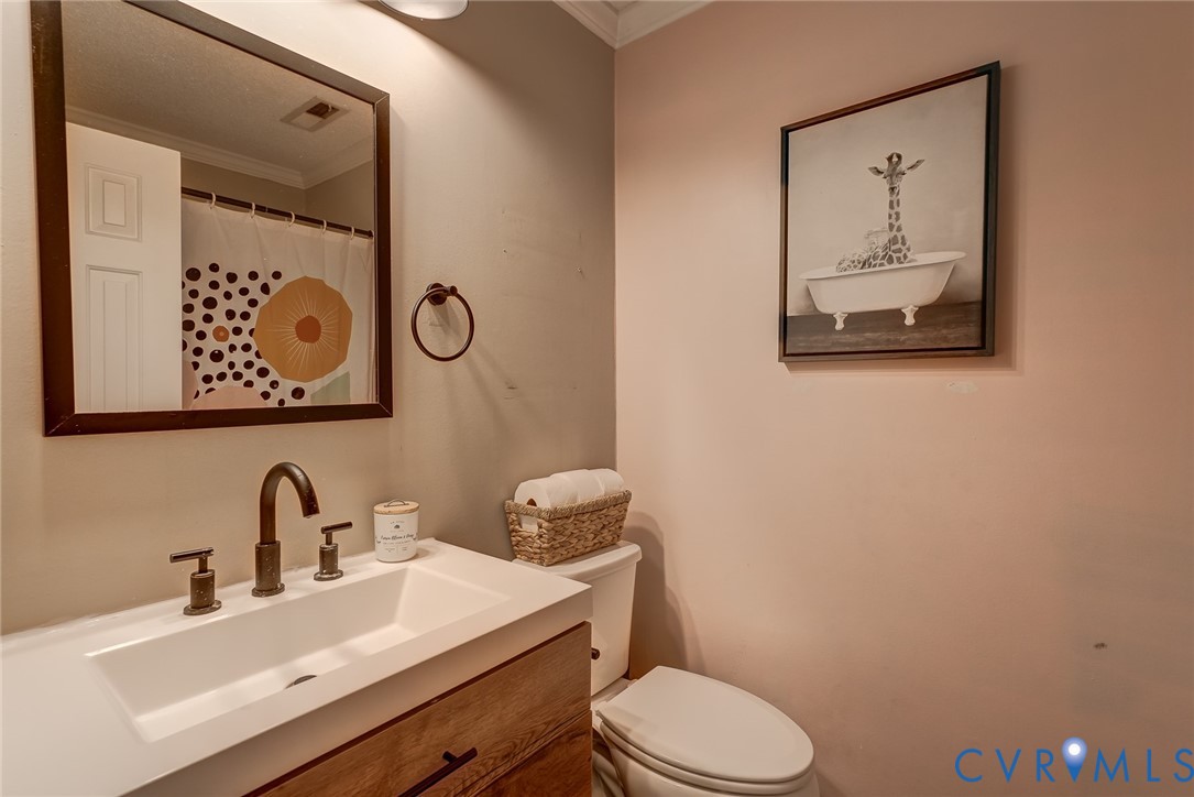 Wood-finish vanity with an integrated rectangular basin and dark bronze-finish fixtures