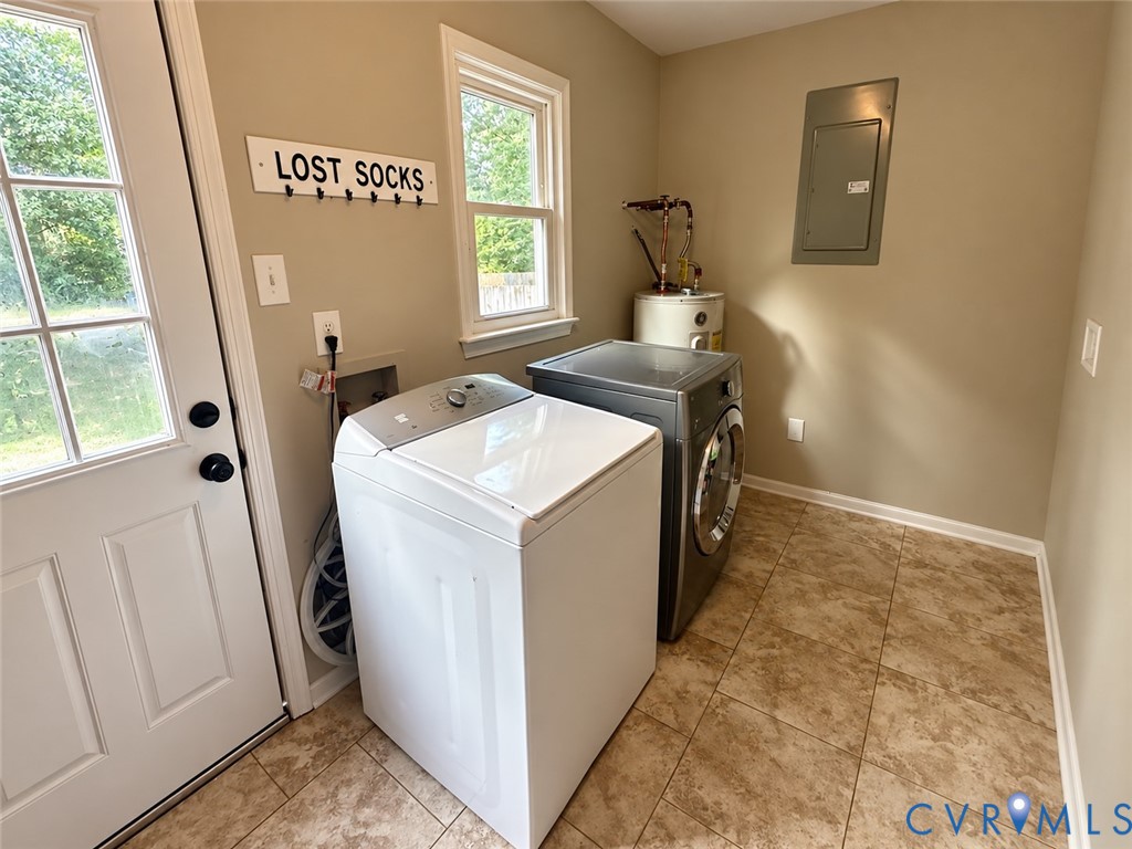 Laundry area featuring a utility door with windowpanes, a window with exterior views, and tile flooring