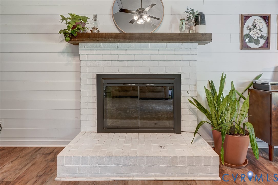 White-painted brick fireplace with a dark metal firebox and a substantial wood mantel