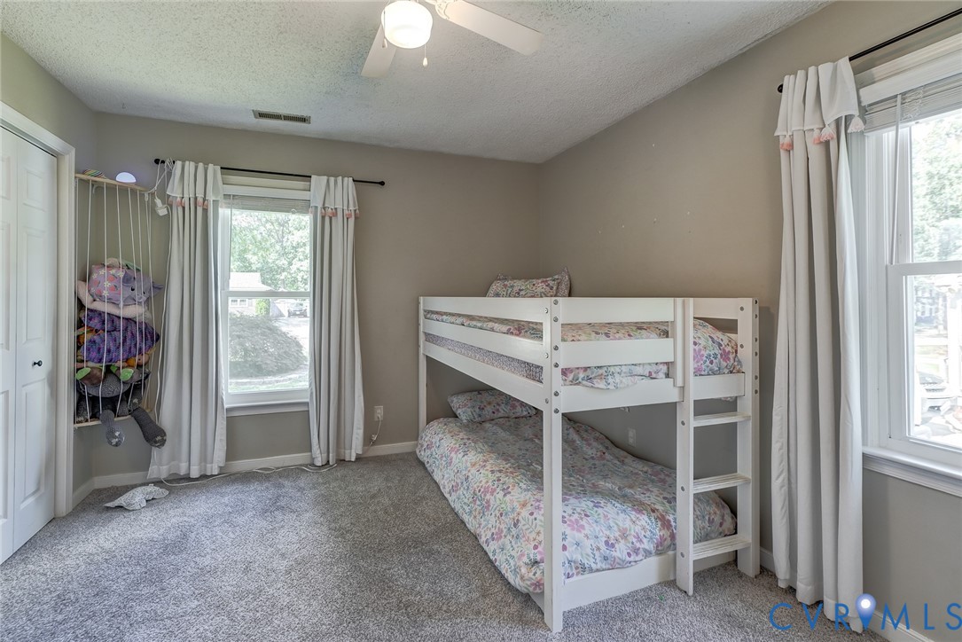 Carpeted room featuring a ceiling fan, a window with blinds, and white painted walls