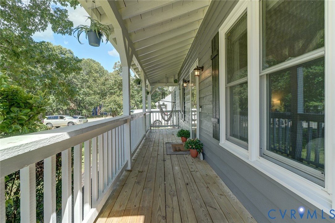 Expansive wood deck with a white railing and covered porch