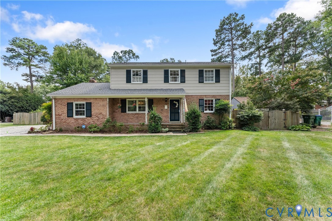 Brick and siding exterior with dark shutters, established landscaping, and a well-maintained lawn Brick and siding exterior with dark shutters, established landscaping, and a well-maintained lawn