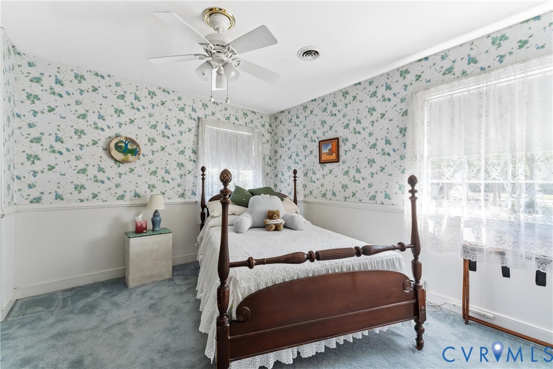 Light blue carpeted flooring with a white ceiling fan and overhead lighting
