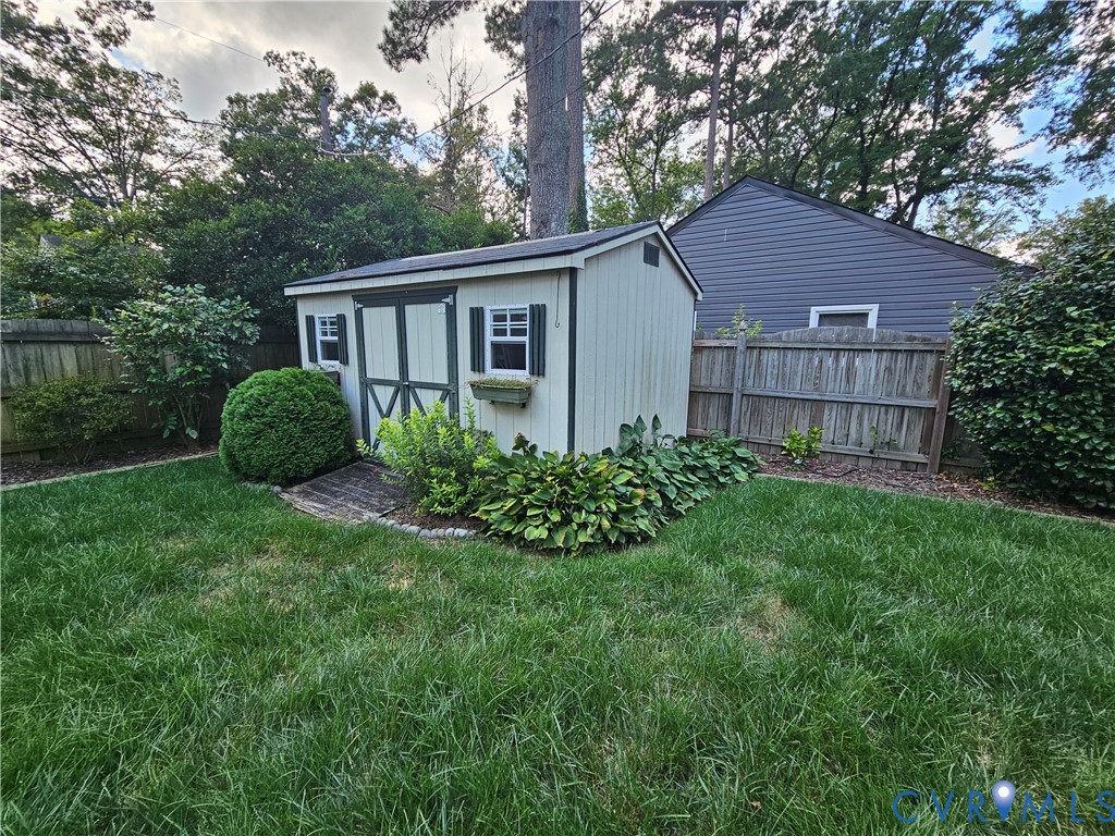 Storage shed with dual doors, white exterior, and dark green trim accents