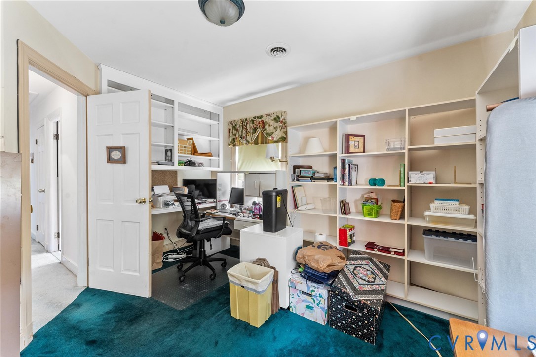 Built-in shelving units, integrated desk space, and a ceiling-mounted light fixture