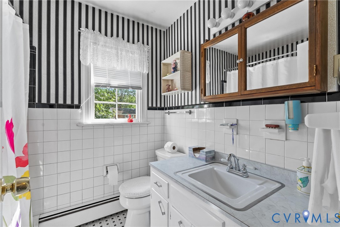 White tiled walls complemented by a black and white striped accent wall