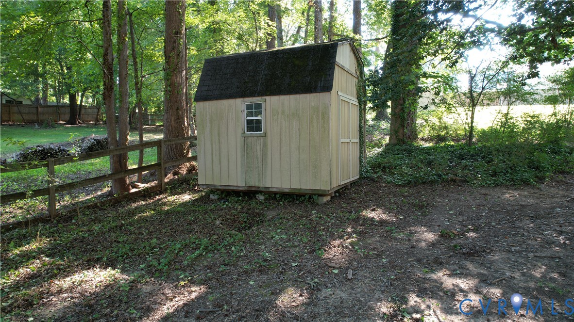 Detached storage shed with a gambrel roof and single window
