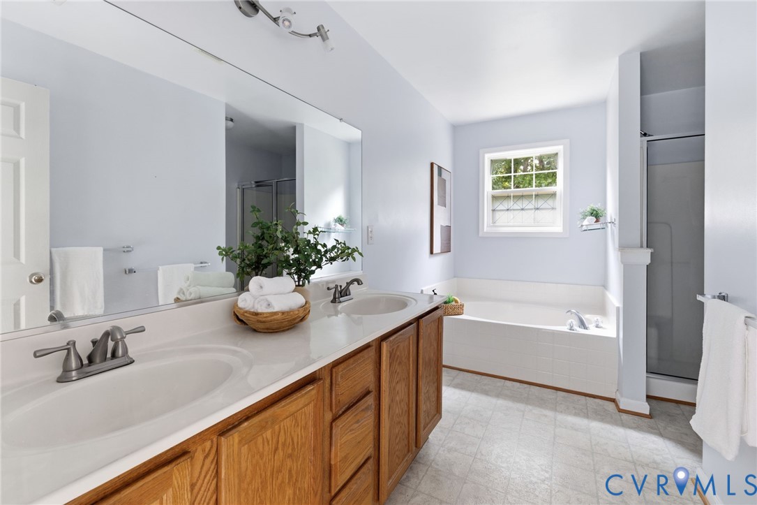 Dual basin vanity with wood-finish cabinetry and an integrated bathtub