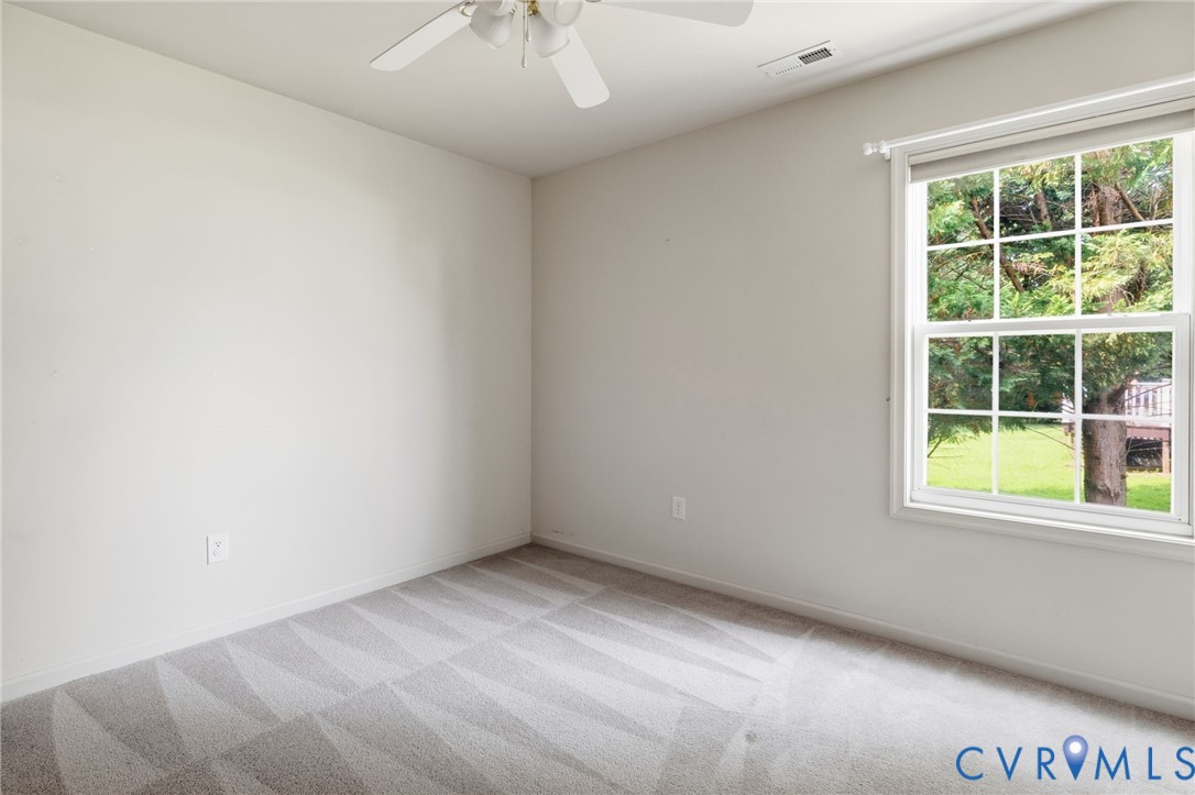 Wall-to-wall patterned carpeting, neutral wall finishes, and a multi-pane window