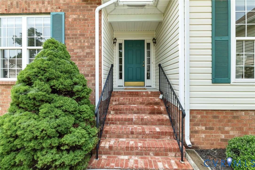 Brick exterior with white window frames and green shutters
