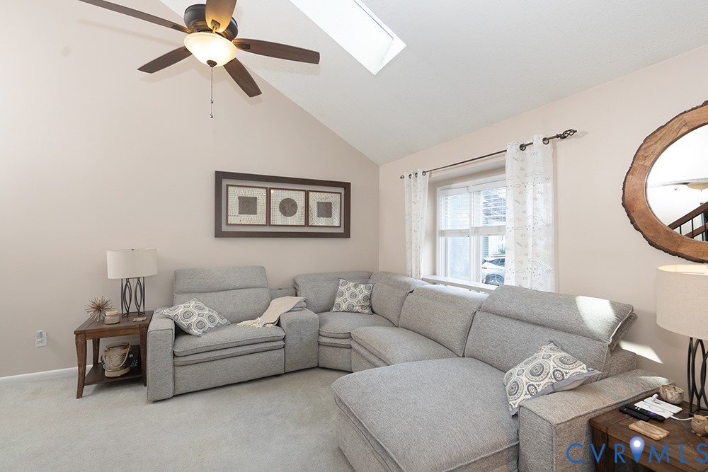 Vaulted ceiling with a skylight and ceiling fan