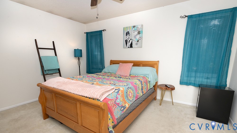 Recessed window with blinds, ceiling fan, and carpeted flooring