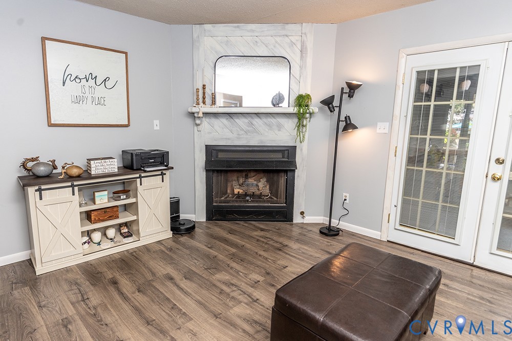 Fireplace with a decorative mantel, wood-finish flooring, and white double French doors
