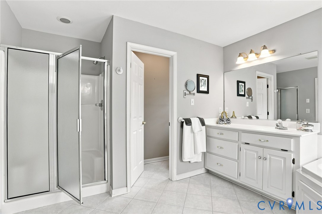 Spacious primary bath features a separate shower, dual vanities, and a neutral color palette.