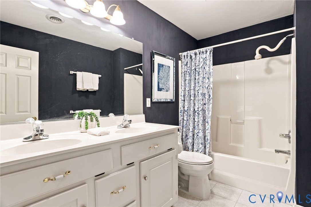 Full bathroom features a double-sink vanity and tub/shower combination.