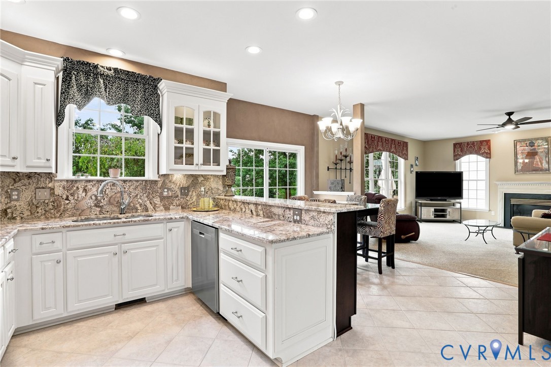 Spacious kitchen features white cabinetry, generous counter space, and an open layout connecting to the family room.
