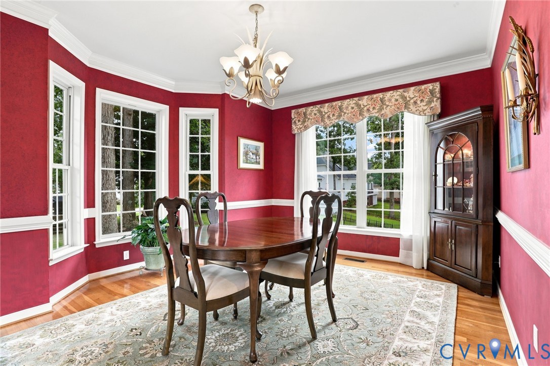 Multiple windows and a bay window fill the formal dining room with natural light.