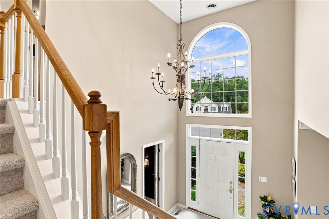 Dramatic two-story foyer features an oversized arched window that fills the entry with natural light.