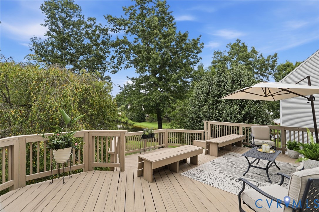 Spacious multi-level deck offers a peaceful setting surrounded by mature trees with scenic water views.