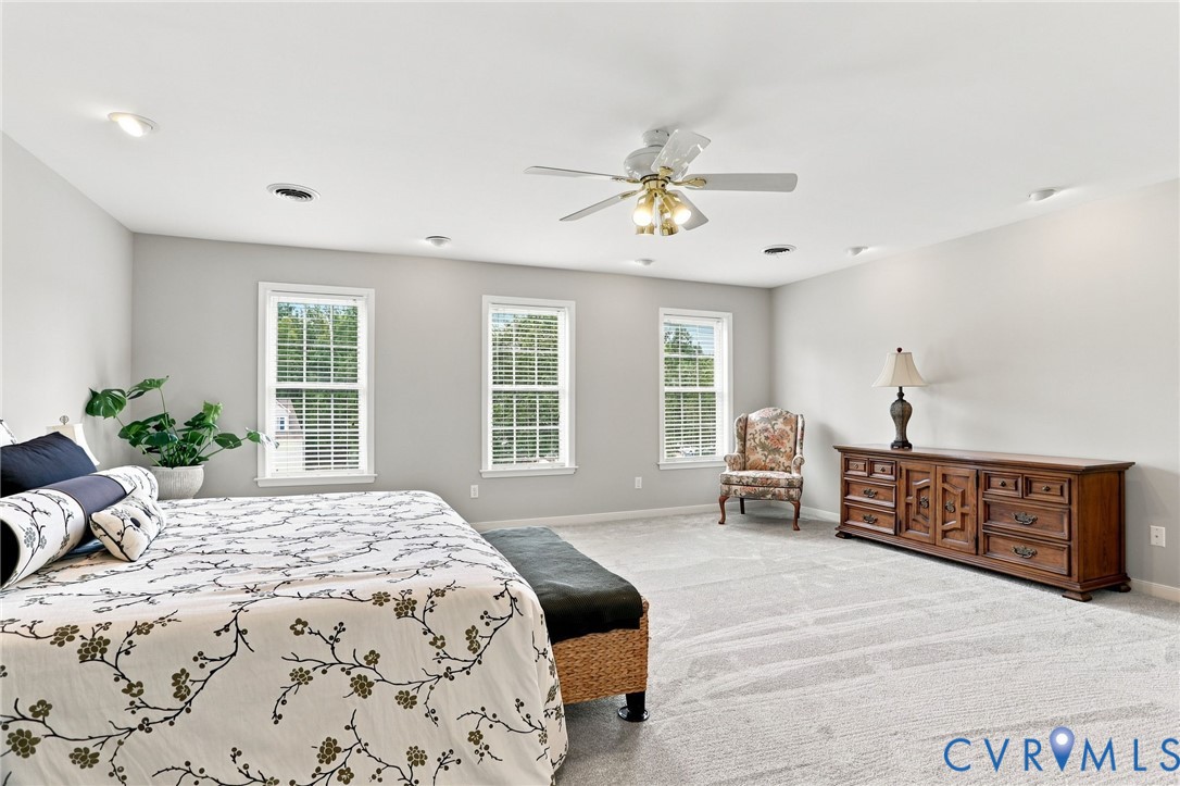Three windows bring natural light into this spacious retreat with plenty of room for additional furniture or a sitting area
