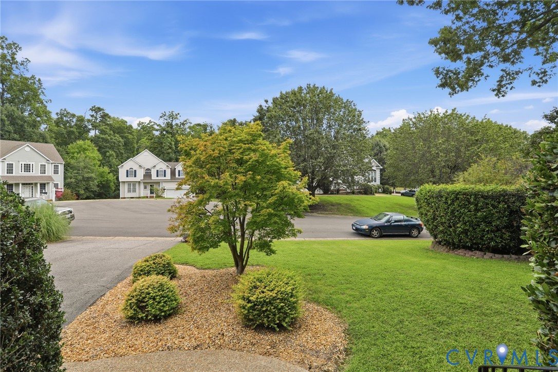 Well-maintained front lawn and landscaping complement the homes attractive neighborhood setting