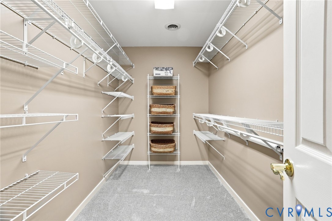 Generously sized walk-in closet offers extensive shelving and hanging space for organized storage.