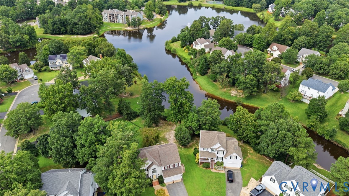 Aerial view showcases the homes beautiful setting within the neighborhood and its proximity to the scenic pond.