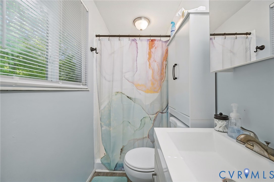 White vanity with integrated sink, chrome-finish faucet, and coordinating mirror