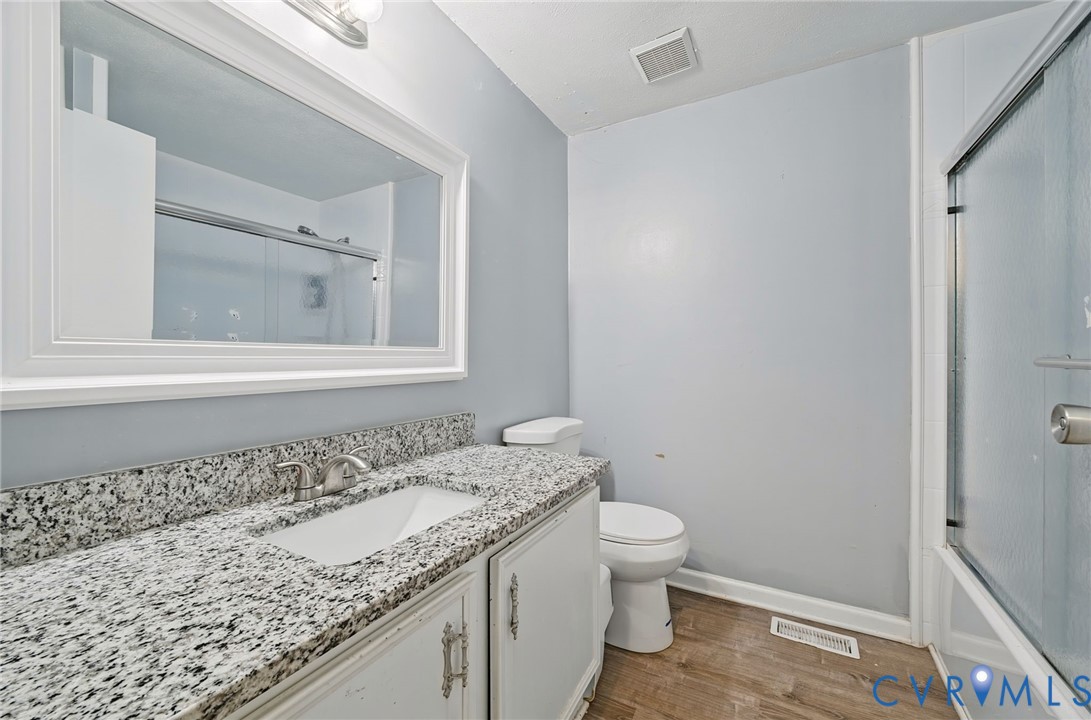 Vanity with granite-style countertop, undermount sink, and brushed nickel faucet