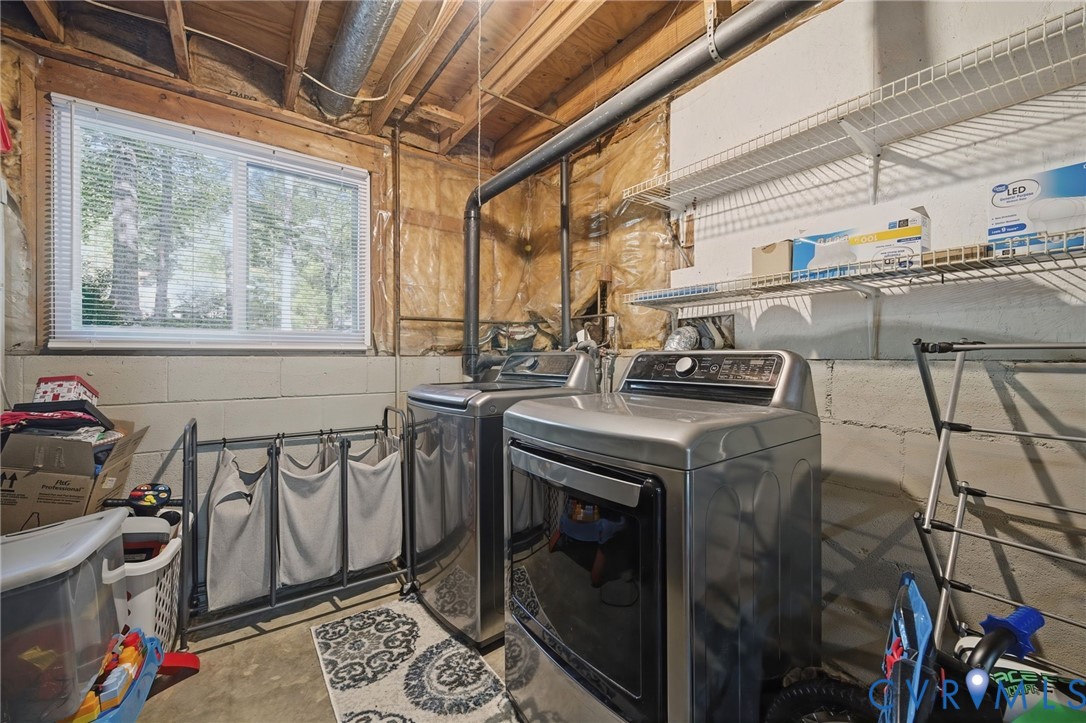 Daylight window with blinds, exposed ceiling joists, utility piping, and built-in wire shelving