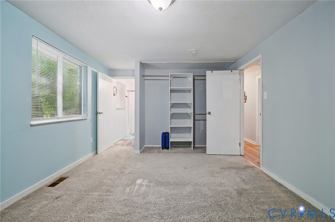 Carpeted flooring, window with blinds, recessed lighting, built-in shelving, and a flush mount ceiling fixture