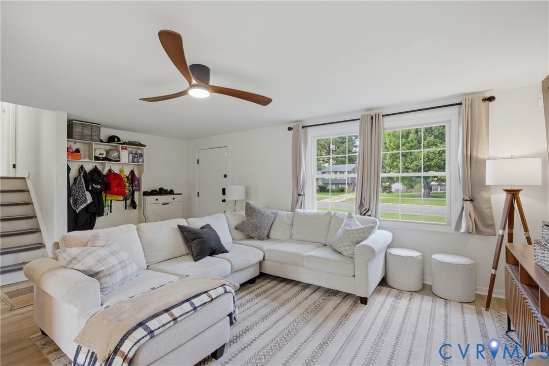 Hardwood-style flooring, a contemporary ceiling fan, and built-in shelving