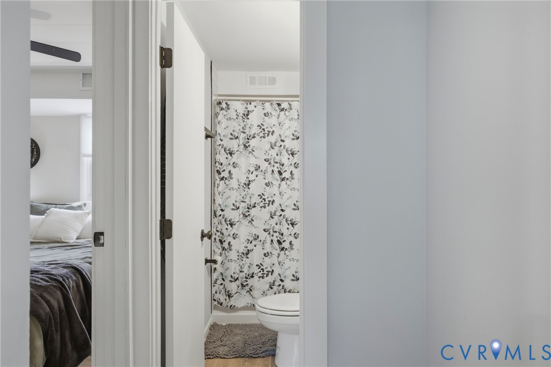Bathroom featuring a shower with a shower curtain and a toilet