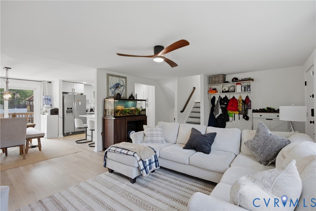 Wood-finish flooring throughout, ceiling fan with integrated lighting, recessed lighting, and a kitchen with stainless steel appliances